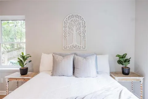 a bedroom with a bed a potted plant and a window