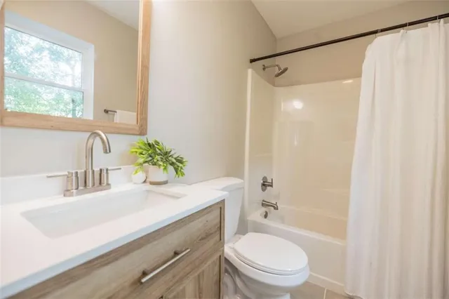 a bathroom with a sink a toilet a mirror and shower