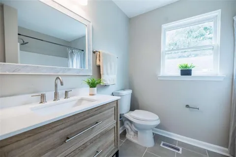 a bathroom with a sink a toilet and a window