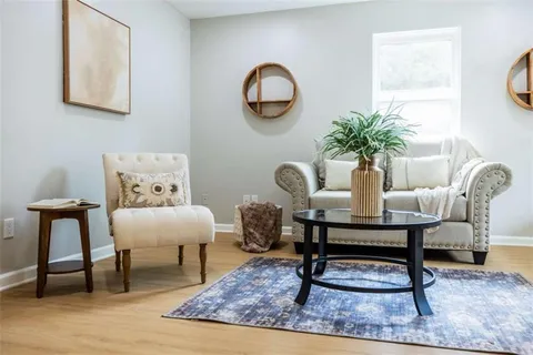 a living room with furniture a rug and a window