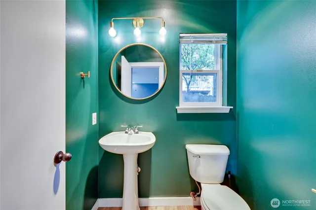 a bathroom with a toilet sink and mirror