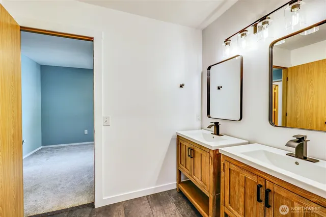 a bathroom with double vanity sink and a mirror
