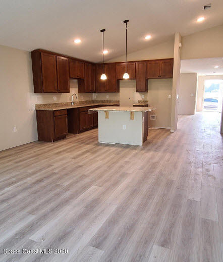 1179 Dania Circle Palm Bay, FL 32905 - Photo 3 of 11 a large kitchen with stainless steel appliances kitchen island a large counter top a sink and a stove