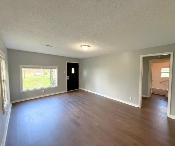 433 Dixie Road Memphis, TN 38109 - Photo 7 of 11 an empty room with wooden floor and windows