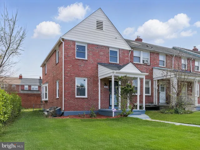 front view of a brick house with a yard
