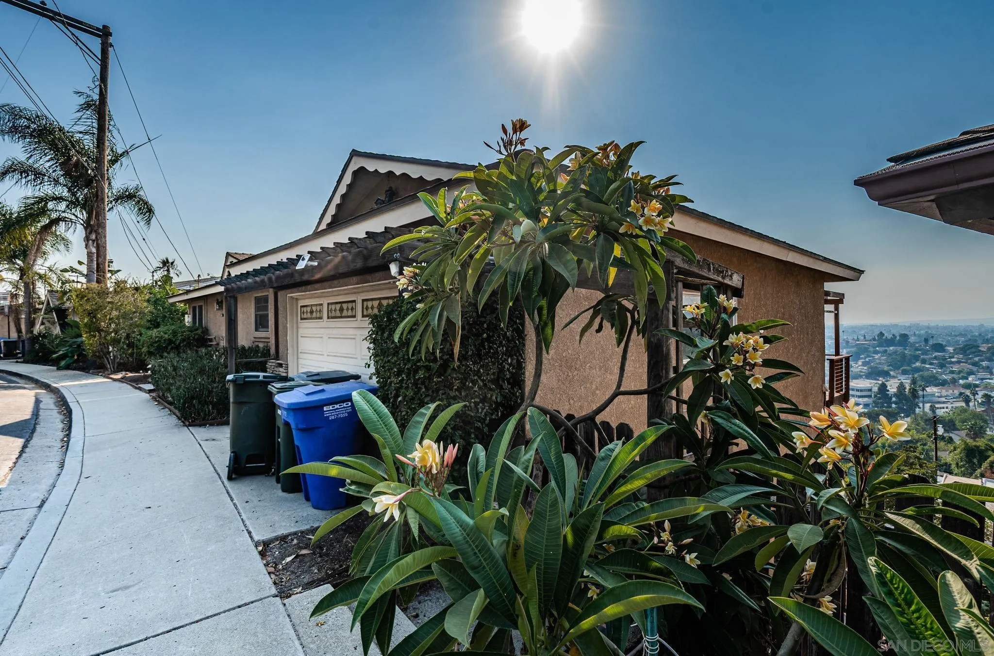 a backyard of a house with table and chairs potted plants