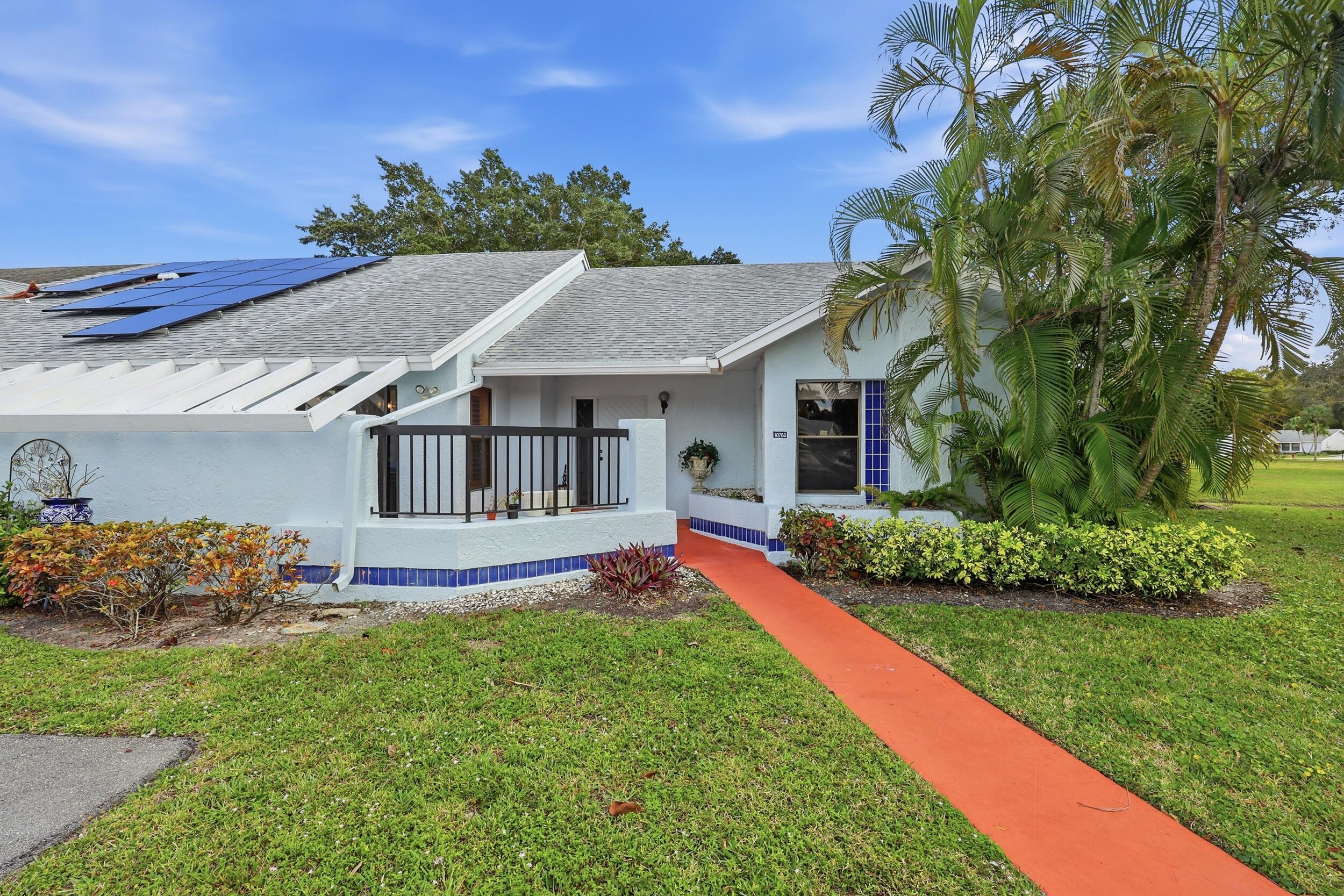 10768 Waterberry Drive Boca Raton, FL 33498 - Photo 1 of 26 a view of a house with a big yard potted plants and large tree
