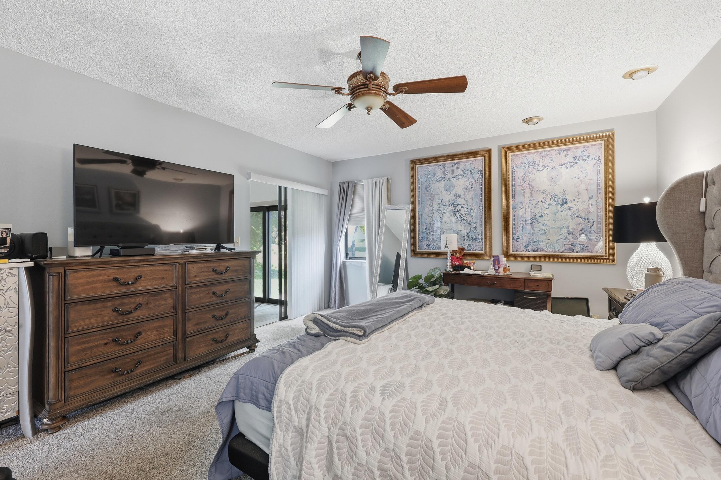 10768 Waterberry Drive Boca Raton, FL 33498 - Photo 11 of 26 a bedroom with a bed and a flat screen tv