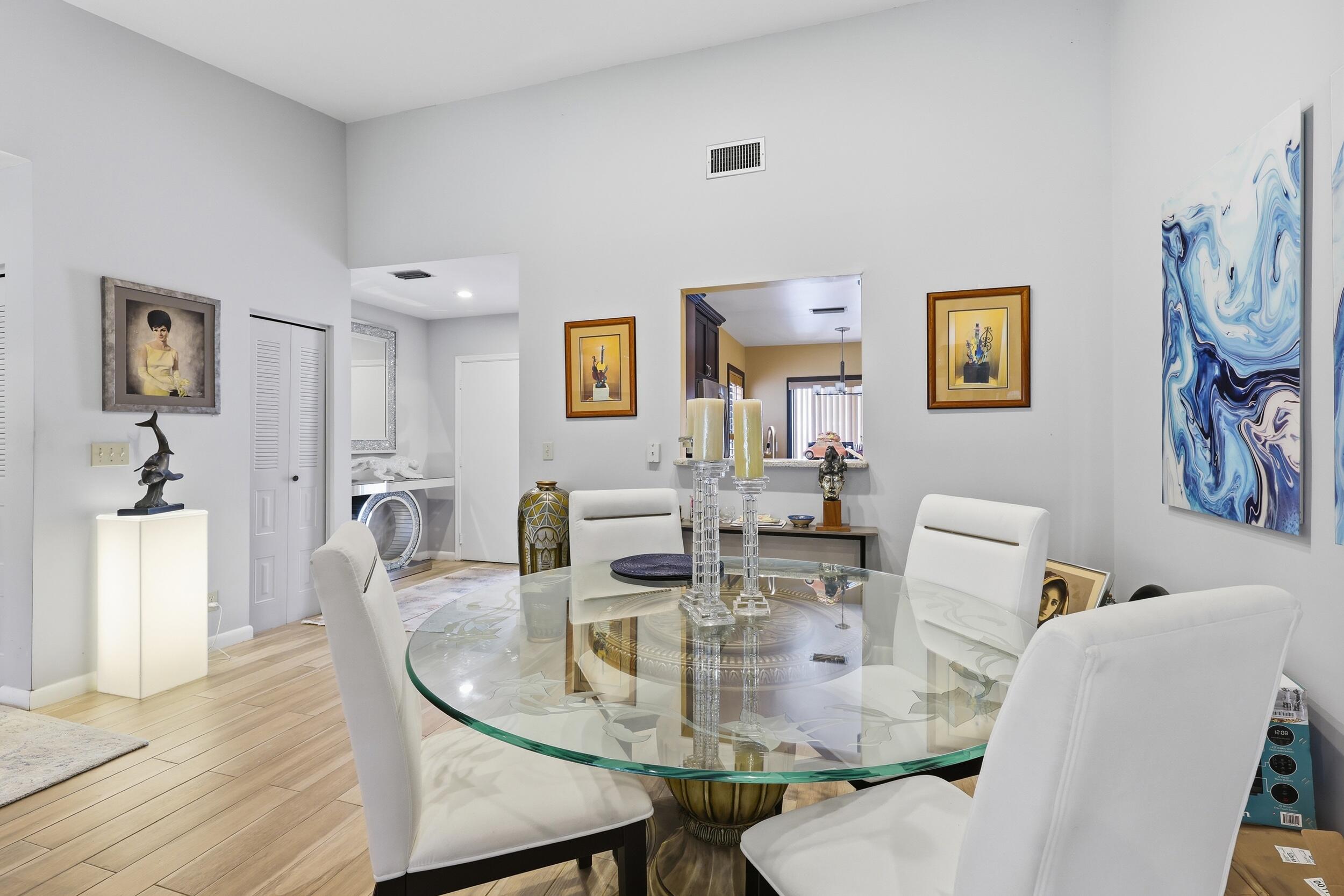10768 Waterberry Drive Boca Raton, FL 33498 - Photo 4 of 26 a view of a dining room with furniture and wooden floor