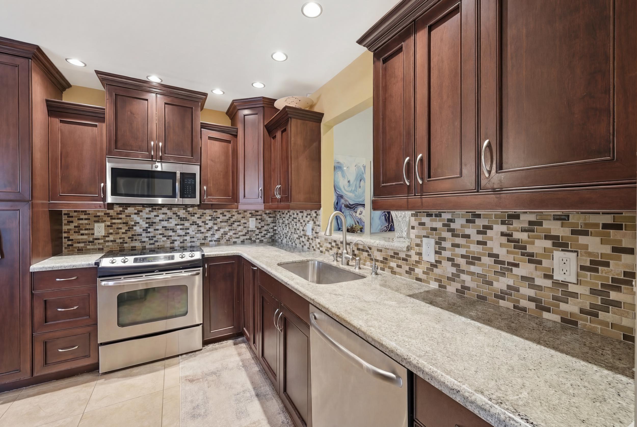 10768 Waterberry Drive Boca Raton, FL 33498 - Photo 7 of 26 a kitchen with stainless steel appliances granite countertop a sink stove and oven