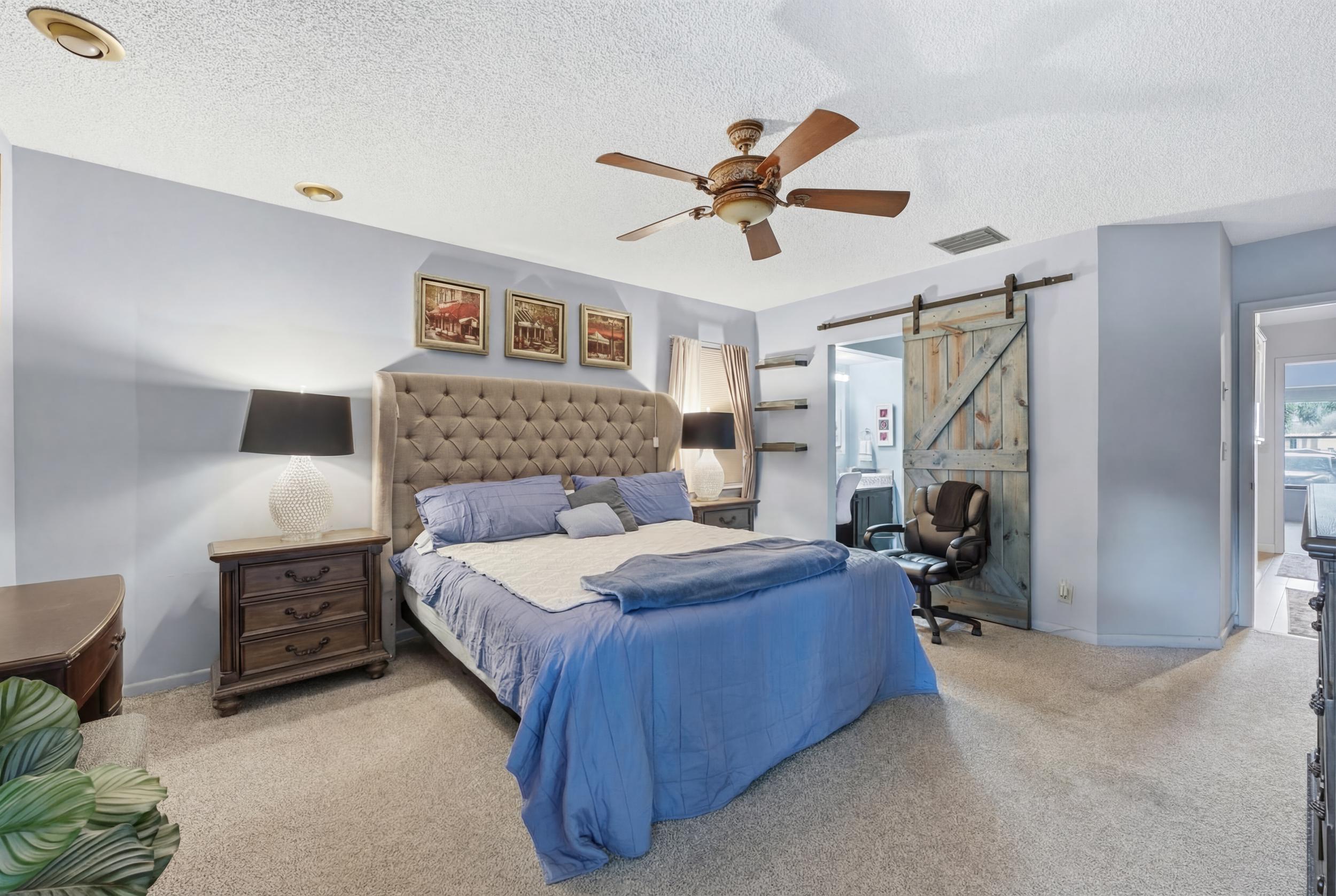 10768 Waterberry Drive Boca Raton, FL 33498 - Photo 10 of 26 a bedroom with a bed and a chandelier
