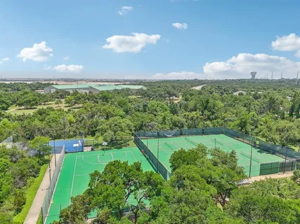 a view of a green yard with large trees