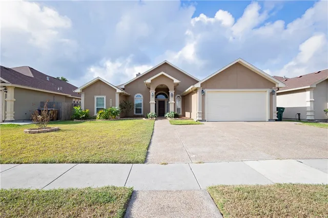 a front view of a house with a garden and plants