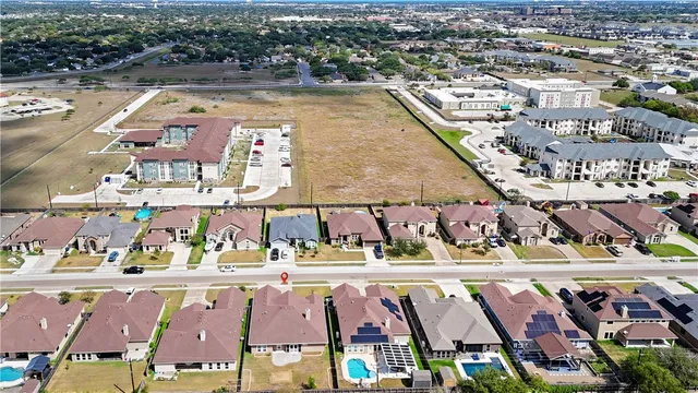 an aerial view of residential houses with outdoor space and ocean view