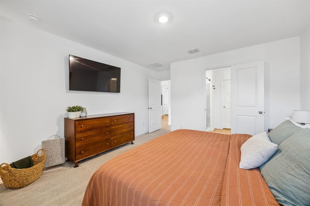 1025 Mountain Laurel Road Princeton, TX 75407 - Photo 11 of 30 a bedroom with a bed and a flat screen tv