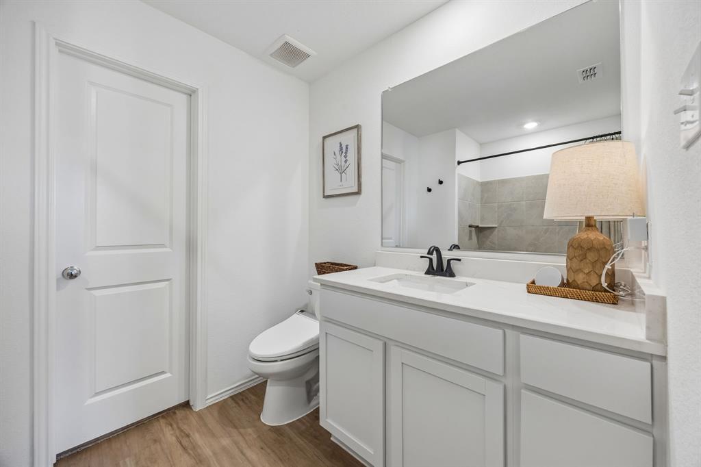 1025 Mountain Laurel Road Princeton, TX 75407 - Photo 12 of 30 a bathroom with a sink a toilet and a mirror