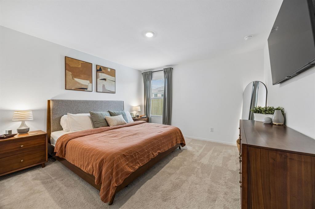 1025 Mountain Laurel Road Princeton, TX 75407 - Photo 20 of 30 a bedroom with a bed and a flat screen tv