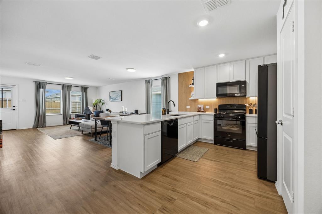 1025 Mountain Laurel Road Princeton, TX 75407 - Photo 3 of 30 a kitchen with sink a microwave and cabinets