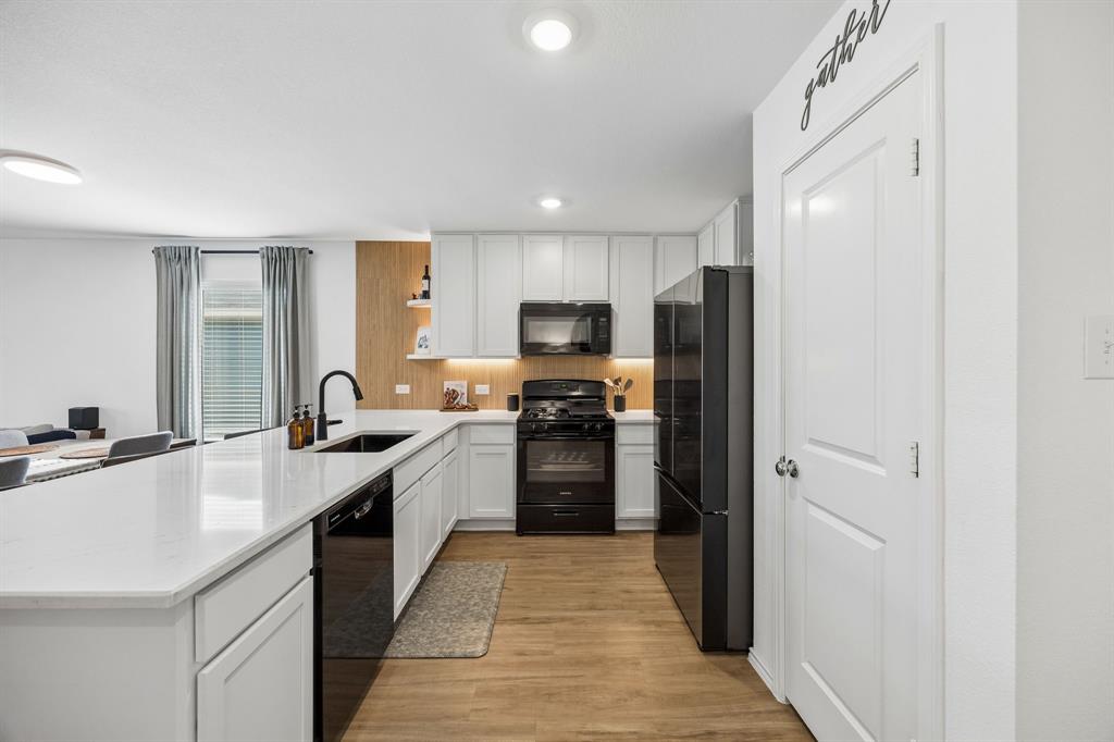 1025 Mountain Laurel Road Princeton, TX 75407 - Photo 4 of 30 a large kitchen with a sink stainless steel appliances and cabinets