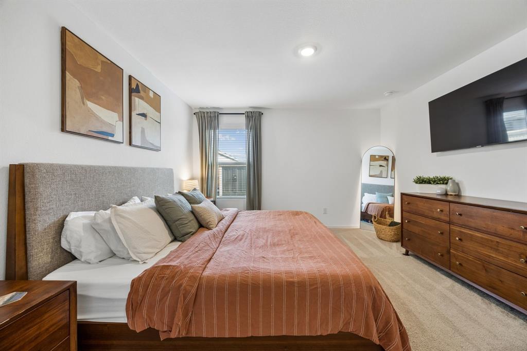 1025 Mountain Laurel Road Princeton, TX 75407 - Photo 10 of 30 a bedroom with a bed and flat screen tv