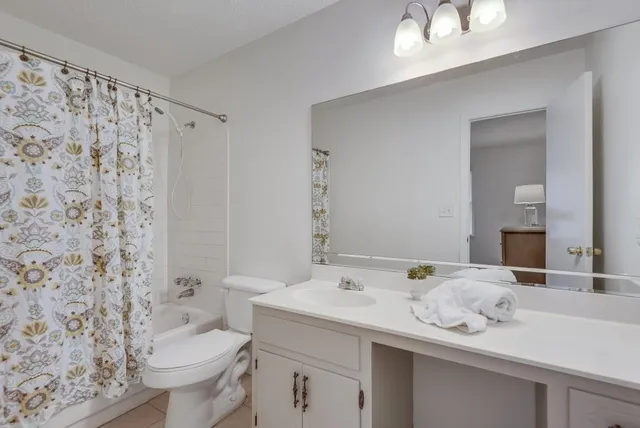 a bathroom with a granite countertop sink a toilet and a mirror