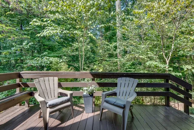 a view of deck with furniture and trees