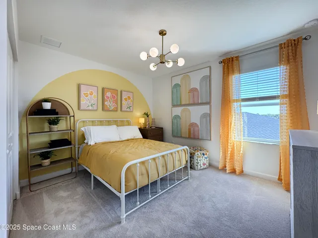 a bedroom with a bed and a chandelier