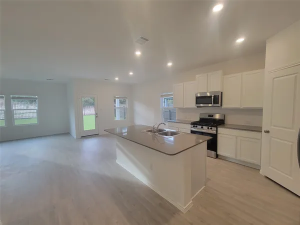 a kitchen with a sink stainless steel appliances and cabinets