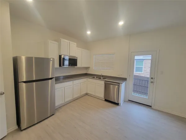 a kitchen with a refrigerator sink and cabinets