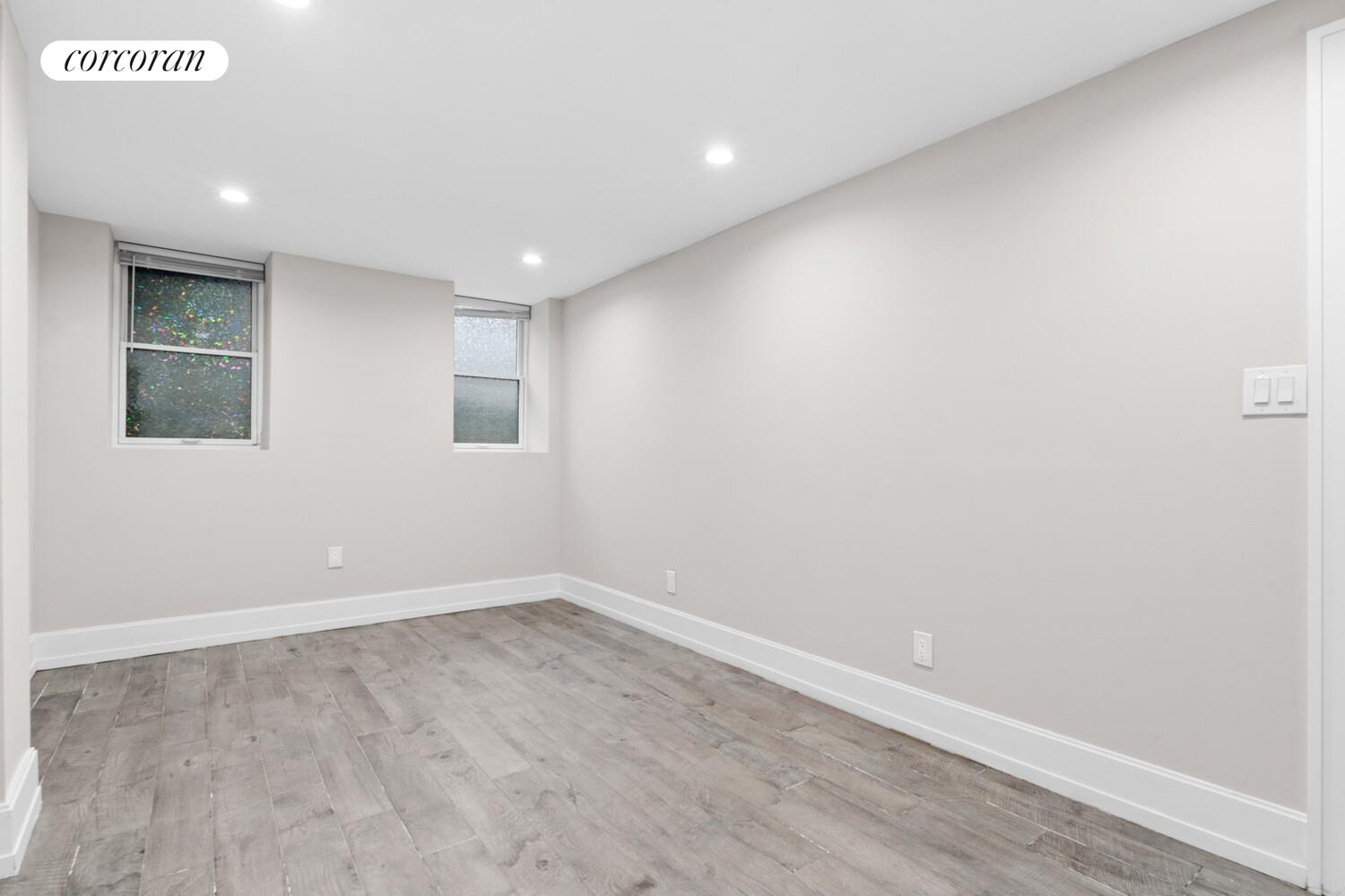 139 Rochester Avenue Brooklyn, NY 11213 - Photo 14 of 17 an empty room with wooden floor and windows
