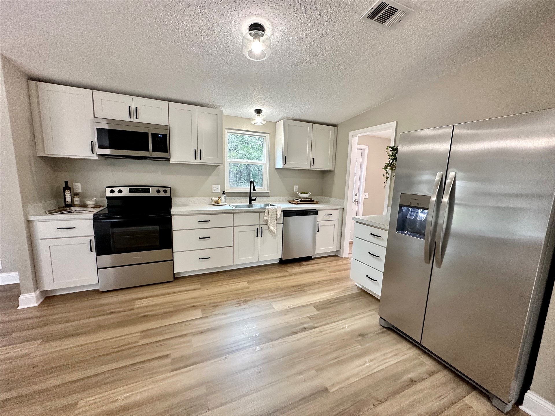 54081 Vikki Road Callahan, FL 32011 - Photo 2 of 6 a kitchen with stainless steel appliances granite countertop a refrigerator stove and sink