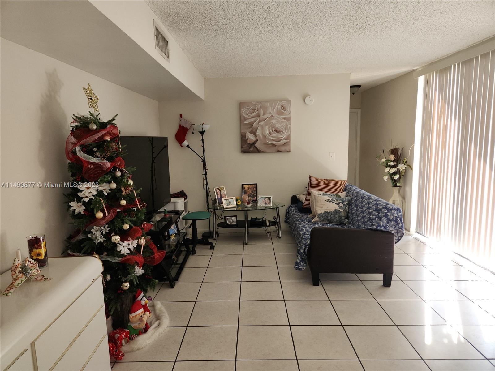 3601 Southwest 117th Avenue, Unit 9104 Miami, FL 33165 - Photo 3 of 9 a living room with furniture and flowers