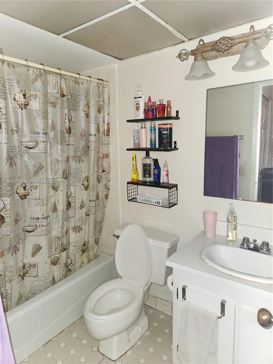 3601 Southwest 117th Avenue, Unit 9104 Miami, FL 33165 - Photo 7 of 9 a bathroom with a granite countertop toilet sink and mirror