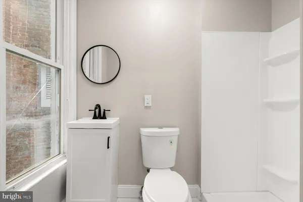 a bathroom with a toilet a sink and a mirror