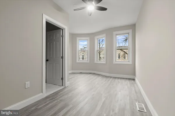an empty room with windows and closet