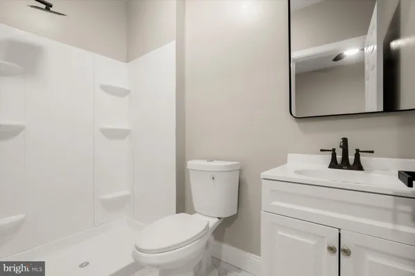 a bathroom with a toilet sink vanity and mirror