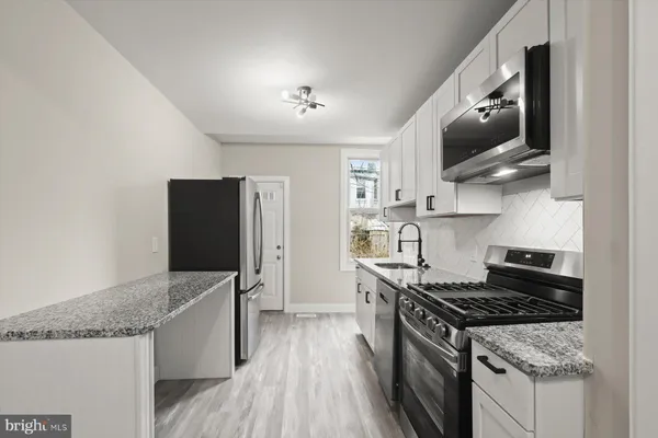 a kitchen with stainless steel appliances granite countertop a stove and a refrigerator