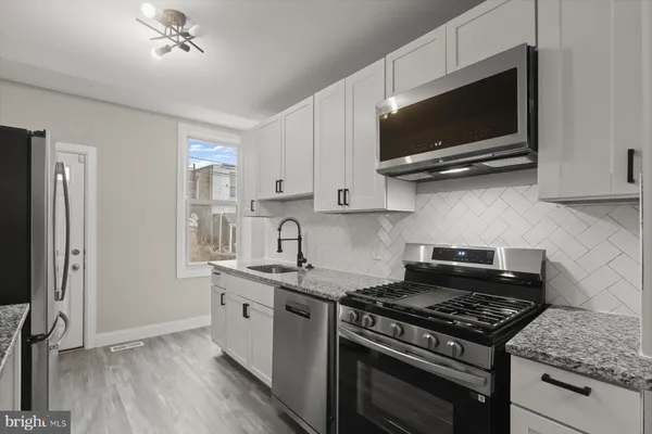 a kitchen with stainless steel appliances a sink a stove and microwave