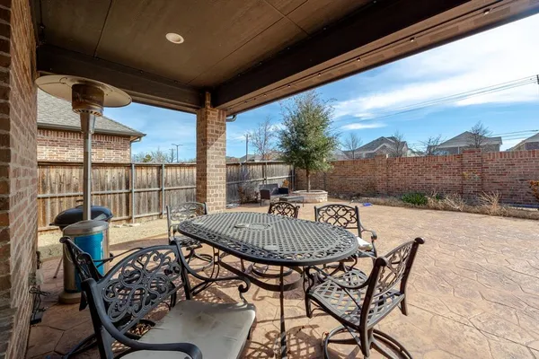 a view of a patio with a table chairs and a backyard
