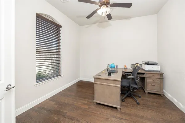 a view of a workspace with furniture and a window