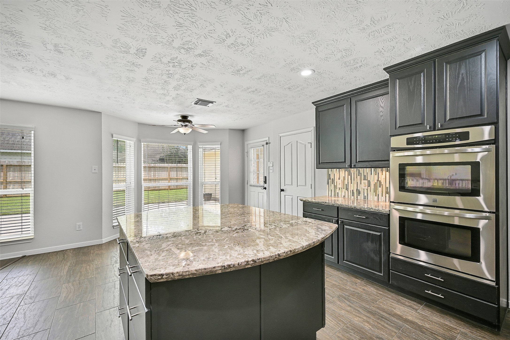 2015 Stonecrest Way Pearland, TX 77581 - Photo 18 of 26 a kitchen with kitchen island granite countertop a stove and a sink