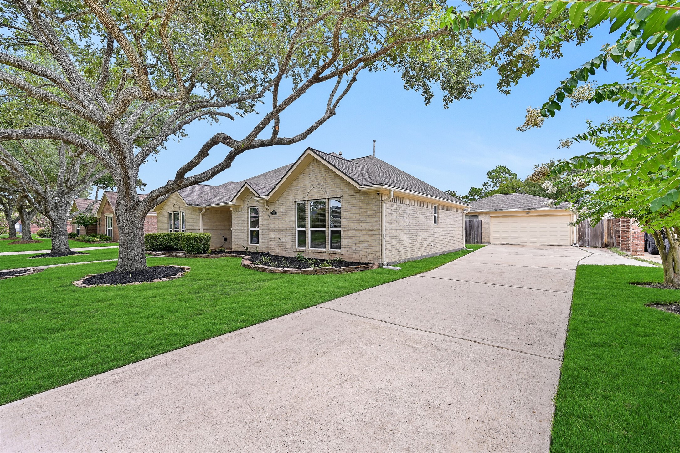 2015 Stonecrest Way Pearland, TX 77581 - Photo 3 of 26 a view of a white house with a big yard and large trees