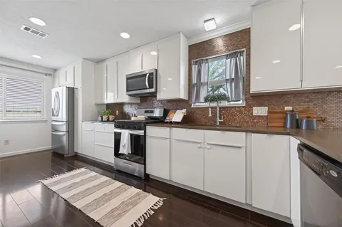 a view of a living room and kitchen with furniture fireplace and wooden floor