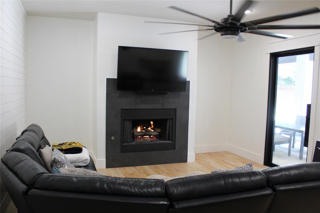 333 Renaissance Lane Heath, TX 75032 - Photo 21 of 35 Living area featuring a modern black fireplace with a mounted television