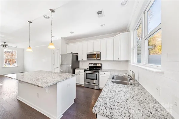 a kitchen with stainless steel appliances granite countertop a sink stove and refrigerator