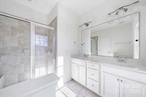 a spacious bathroom with a shower sink and mirror