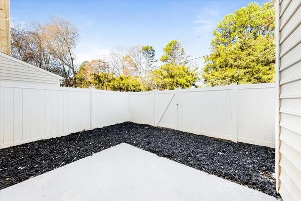 a view of a yard with wooden fence