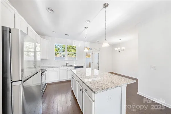 a kitchen with a center island a counter space a sink and appliances