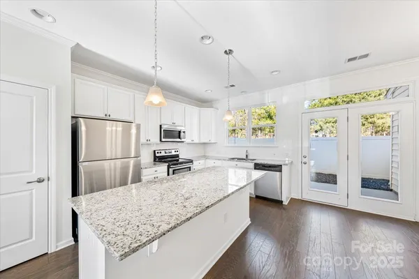 a kitchen with stainless steel appliances granite countertop a sink refrigerator and microwave