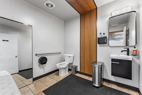 a bathroom with a toilet a sink and mirror